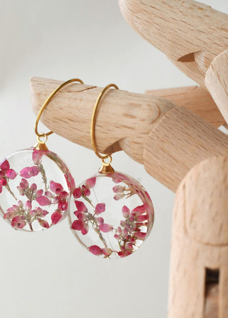 Handmade resin earrings featuring dried heather flowers on gold hoops