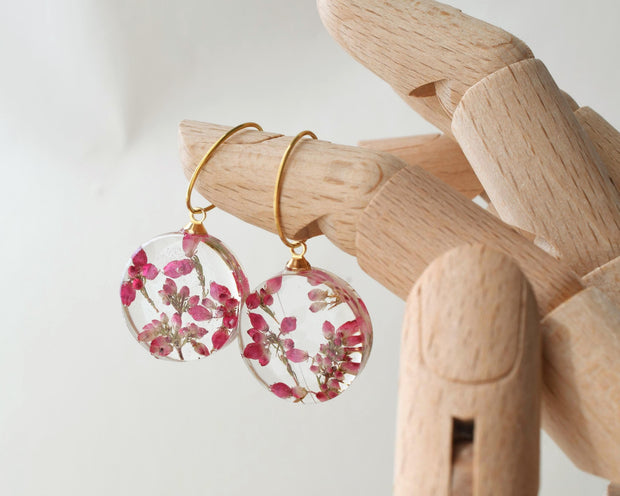 Handmade resin earrings featuring dried heather flowers on gold hoops