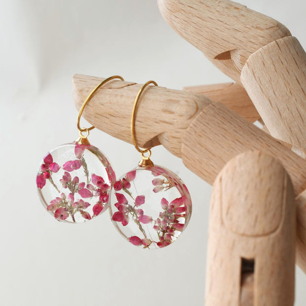 Handmade resin earrings featuring dried heather flowers on gold hoops