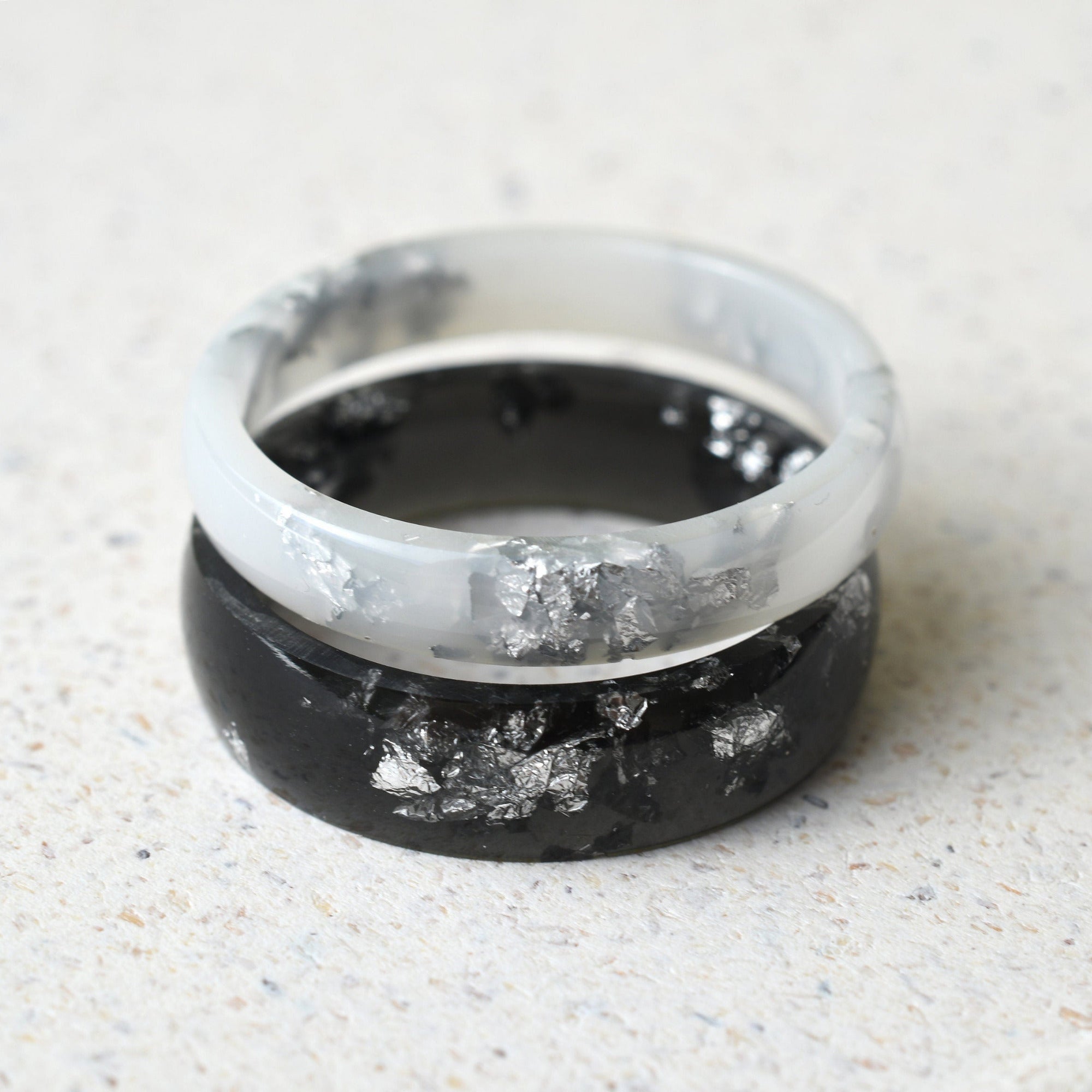 Matching black and white resin couple rings with silver leaf handmade by Resity in Vienna