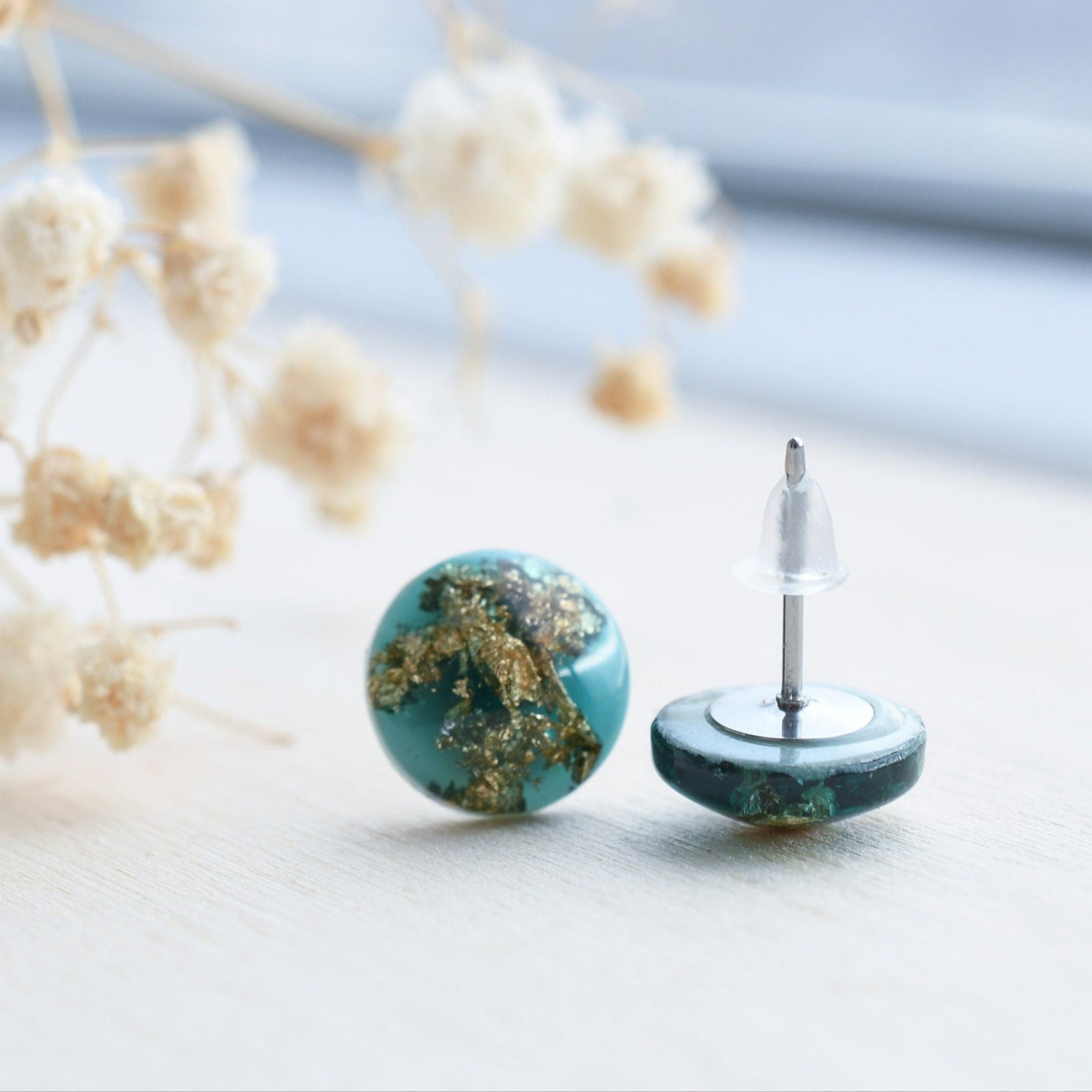 Close-up of gold flakes suspended in emerald resin handmade earrings