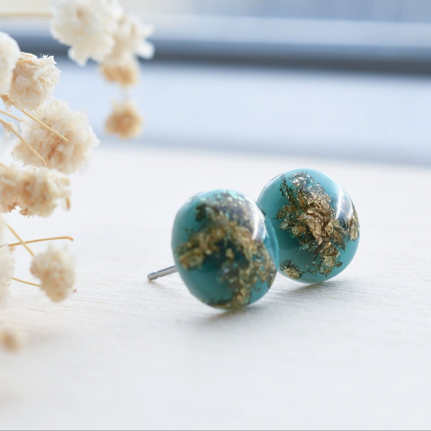 Dainty emerald resin stud earrings with shimmering gold leaf