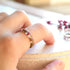 Faceted pink heather resin ring worn on hand