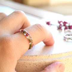 Faceted pink heather resin ring worn on hand