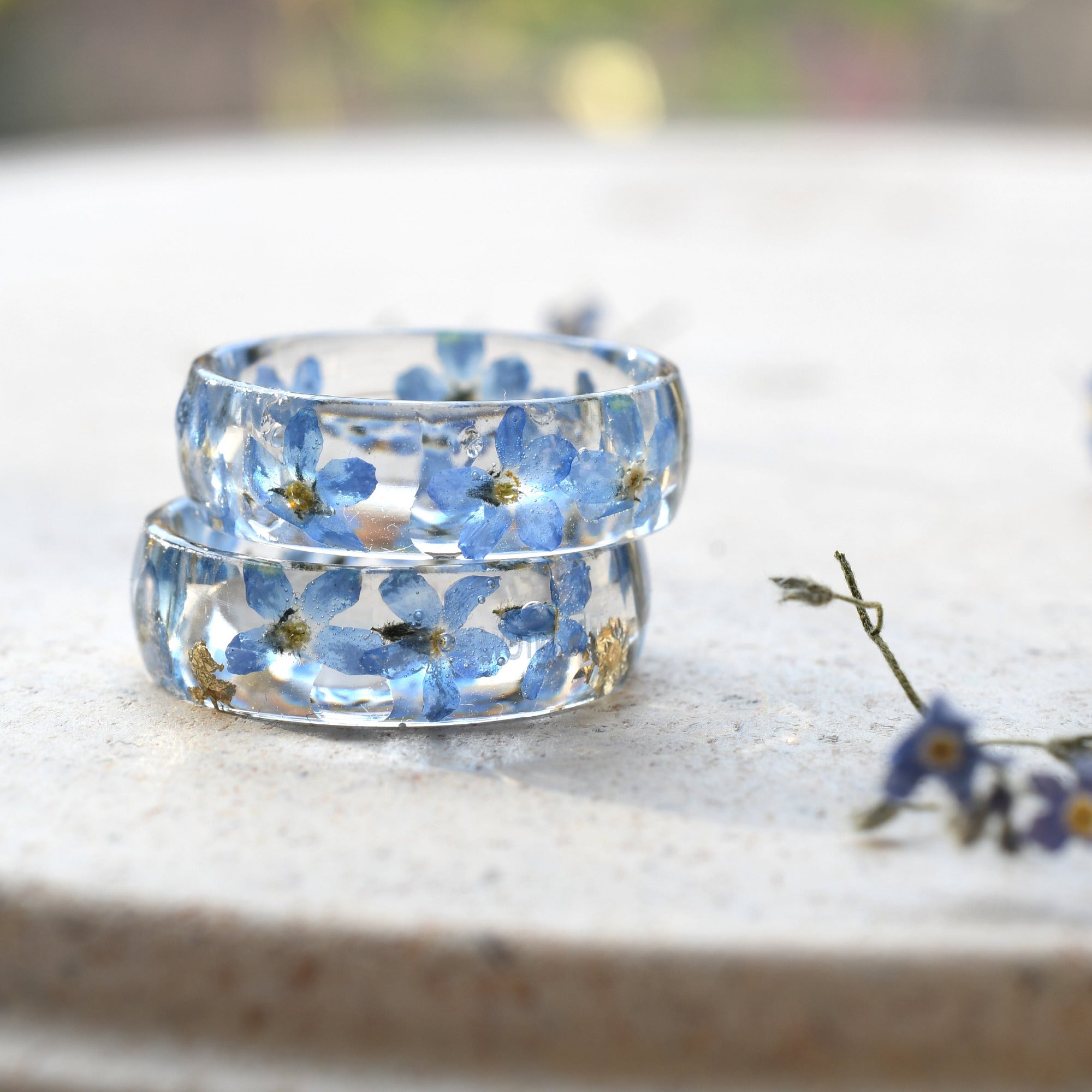 Transparent resin ring featuring real flowers and metallic gold inclusions