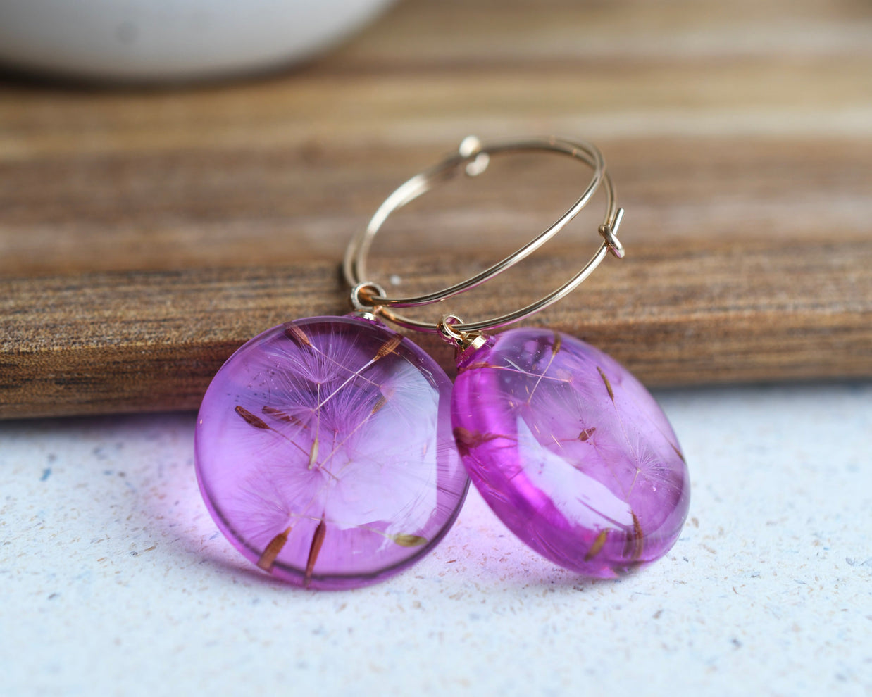 Gold-filled hoop earrings with floating dandelion seeds