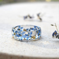 Unique floral resin ring with gold flakes and forget-me-nots on a glossy wide band