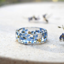 Unique floral resin ring with gold flakes and forget-me-nots on a glossy wide band