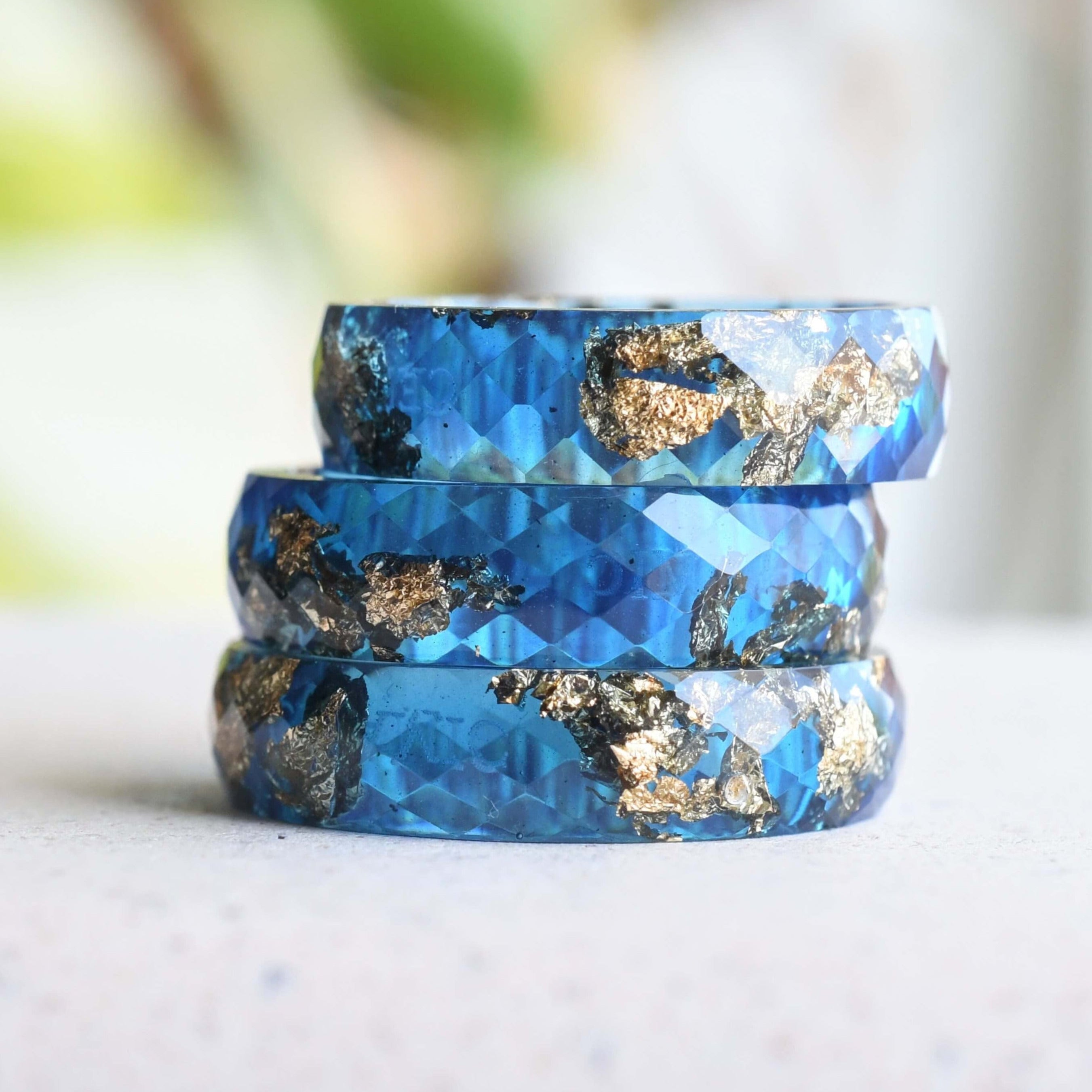 Close-up of gold flakes suspended in sapphire blue resin handmade ring