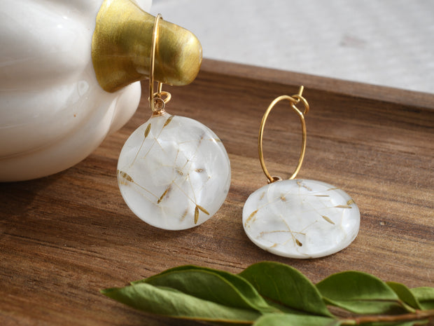 Gold hoop earrings with round resin drops containing real dandelion seeds, lightweight botanical jewelry