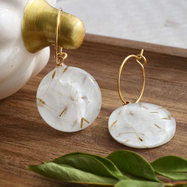 Gold hoop earrings with round resin drops containing real dandelion seeds, lightweight botanical jewelry