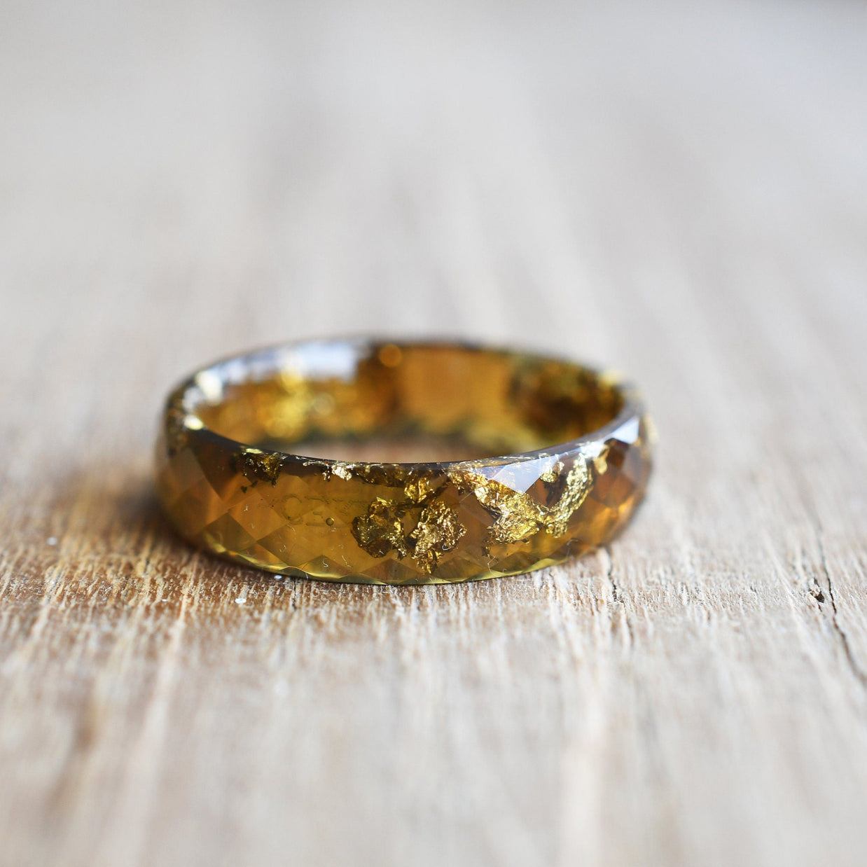 lose-up of gold flakes inside amber resin ring handmade by Resity