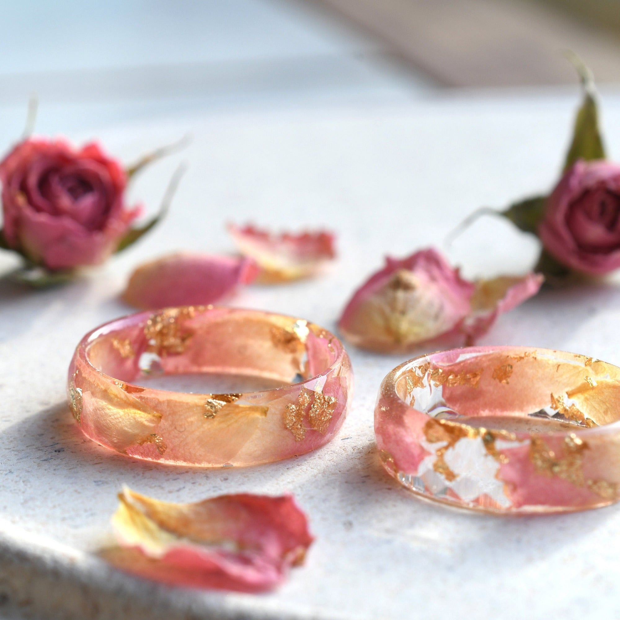 Close-up of faceted resin band with soft pink petals and gold flecks