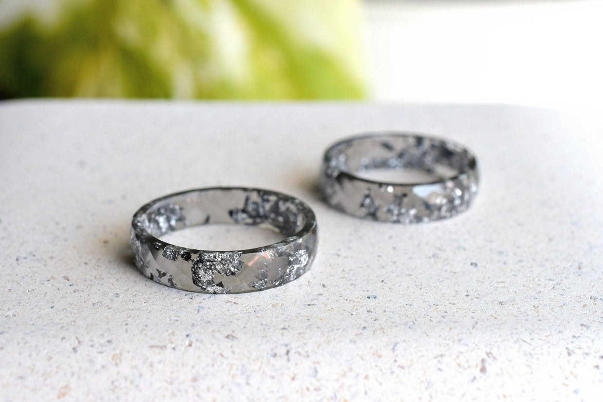 Close-up of silver flakes suspended in faceted grey resin ring