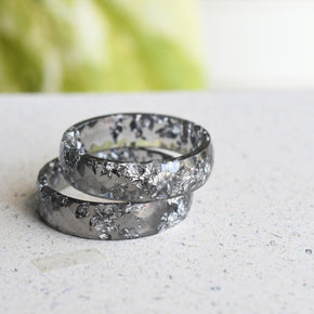 Close-up of silver flakes suspended in faceted grey resin ring 2