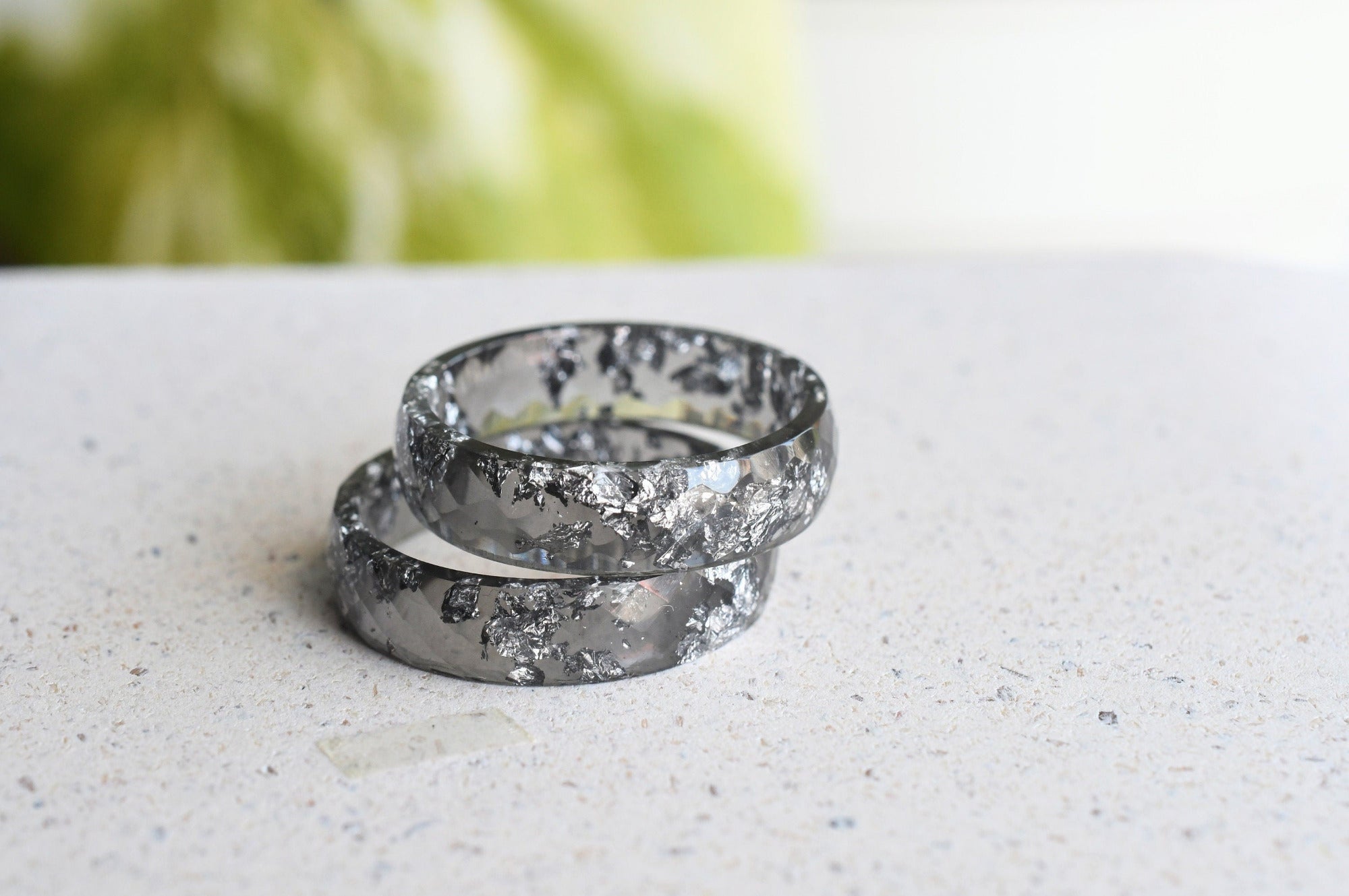 Close-up of silver flakes suspended in faceted grey resin ring 2