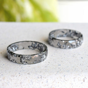 Close-up of silver flakes suspended in faceted grey resin ring
