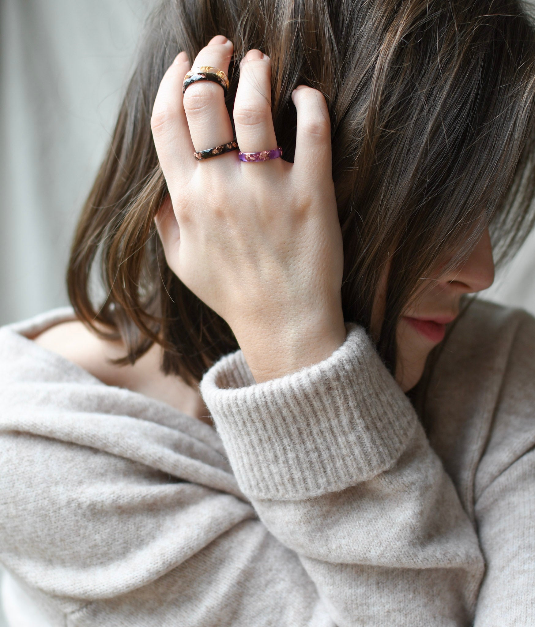 Stackable thin purple resin ring with gold flakes worn by model