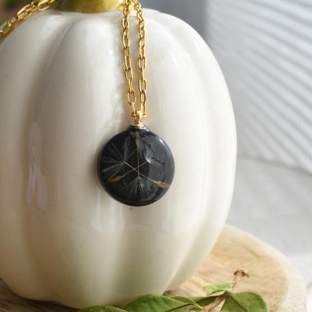 Handmade dandelion seed necklace in glossy black resin with gold-plated link chain