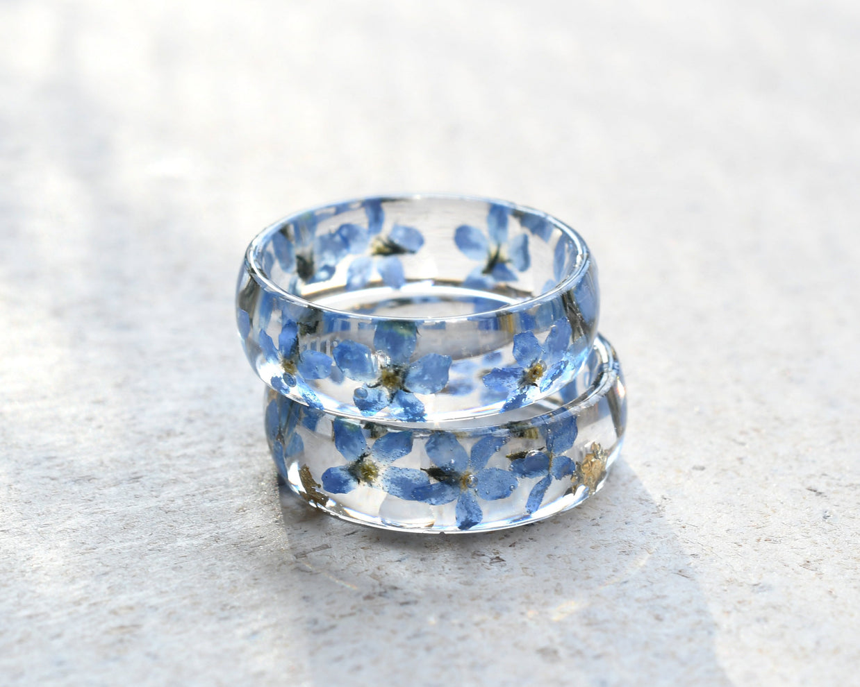 Clear ring with blue floral design on a light gray surface