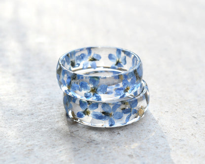 Clear ring with blue floral design on a light gray surface