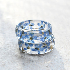 Clear ring with blue floral design on a light gray surface