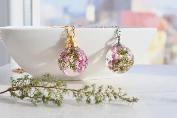 Close-up of 19mm resin globe pendant with dried pink heather flowers inside
