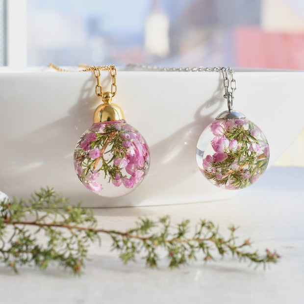 Close-up of 19mm resin globe pendant with dried pink heather flowers inside