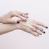 Hands with temporary tattoos on a light pink background