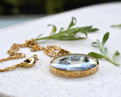 Forget-me-not resin pendant displayed on a tray, highlighting the intricate flower details and crystal-clear resin.