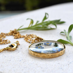 Forget-me-not resin pendant displayed on a tray, highlighting the intricate flower details and crystal-clear resin.