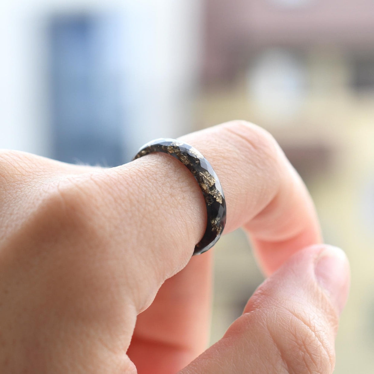 Thin faceted black resin ring with gold metallic leaf, perfect for stacking or as a wedding ring.