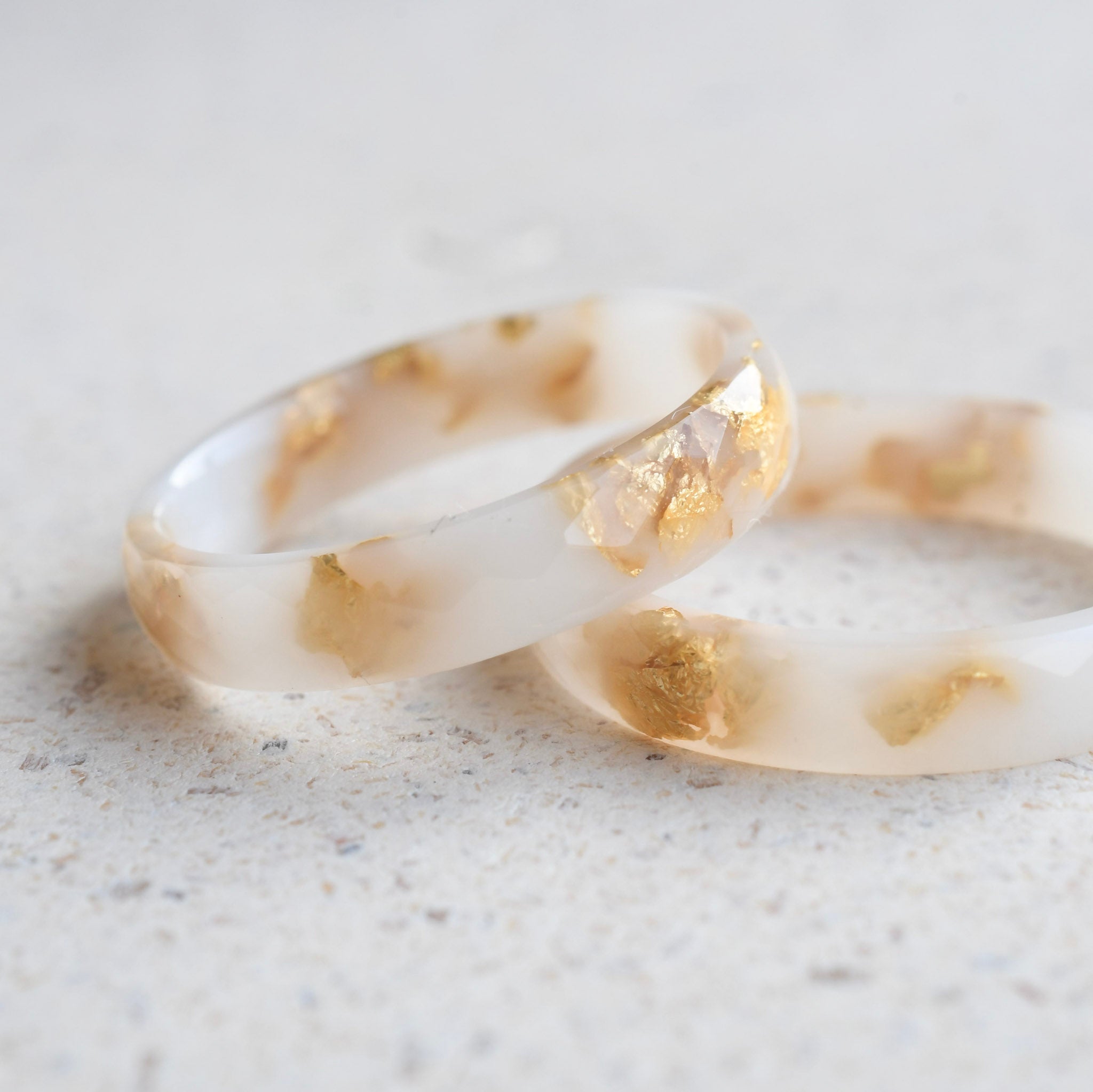 Slim white resin stacking ring with metallic gold leaf handmade in Vienna