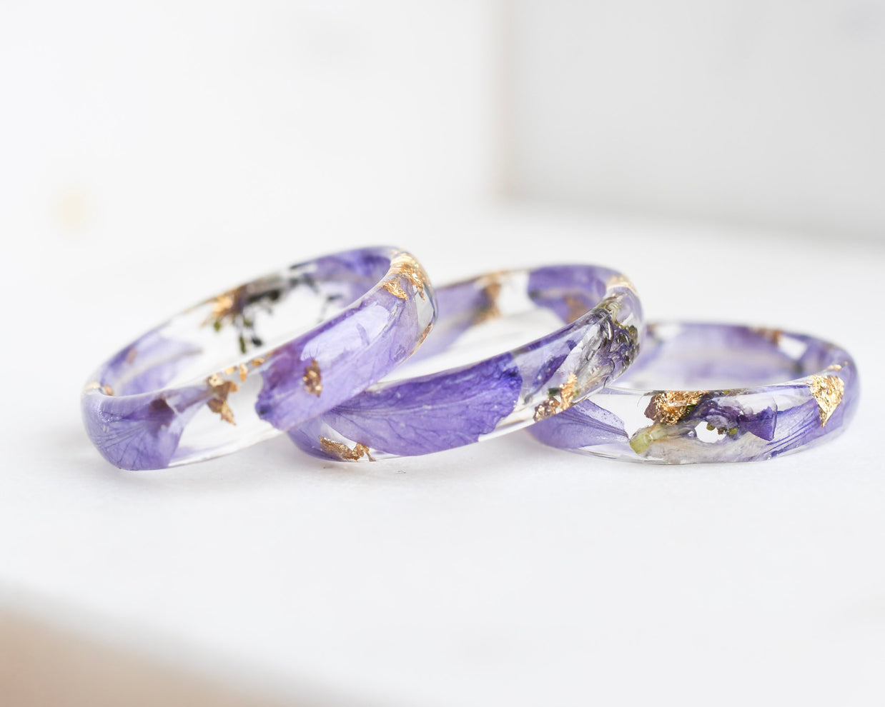 Three purple rings with gold accents on a white background