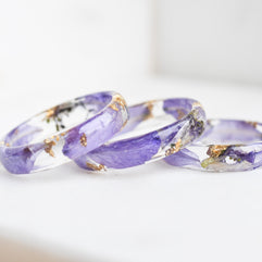 Three purple rings with gold accents on a white background