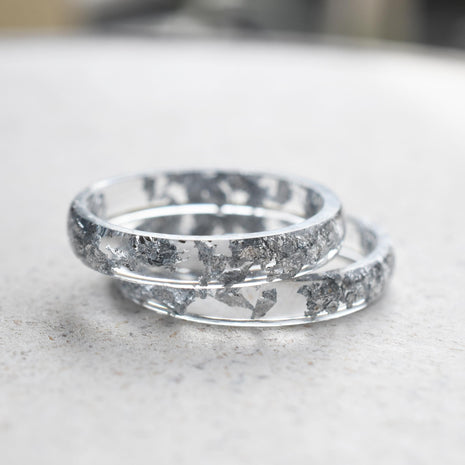 Flatlay of Lumen Ring showing transparent resin band with silver leaf accents