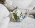 Round pendant with floral design on a branch and stones