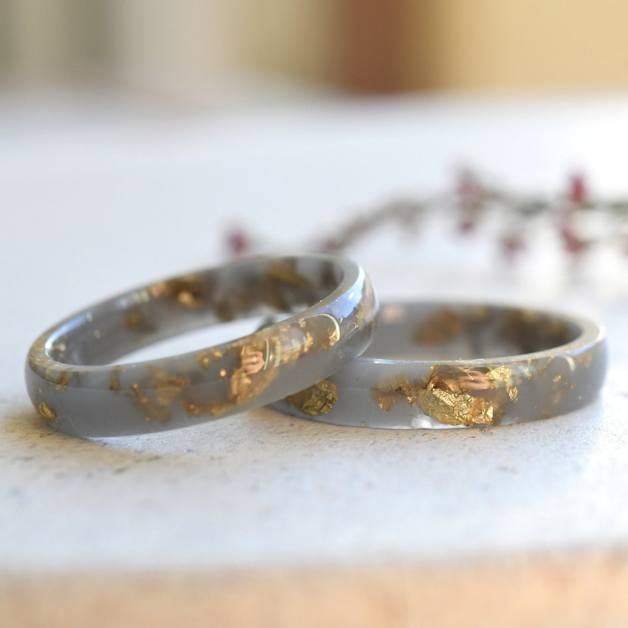 Close-up of gold flakes suspended in matte gray resin handmade ring