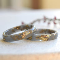 Close-up of gold flakes suspended in matte gray resin handmade ring