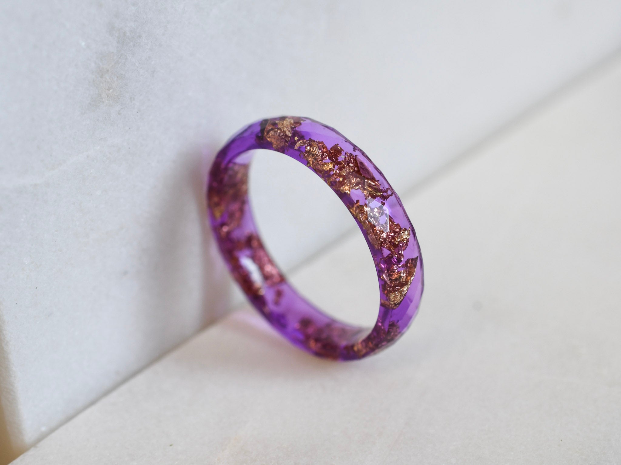 Thin purple resin ring with gold leaf worn on hand