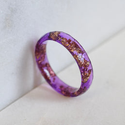 Thin purple resin ring with gold leaf worn on hand