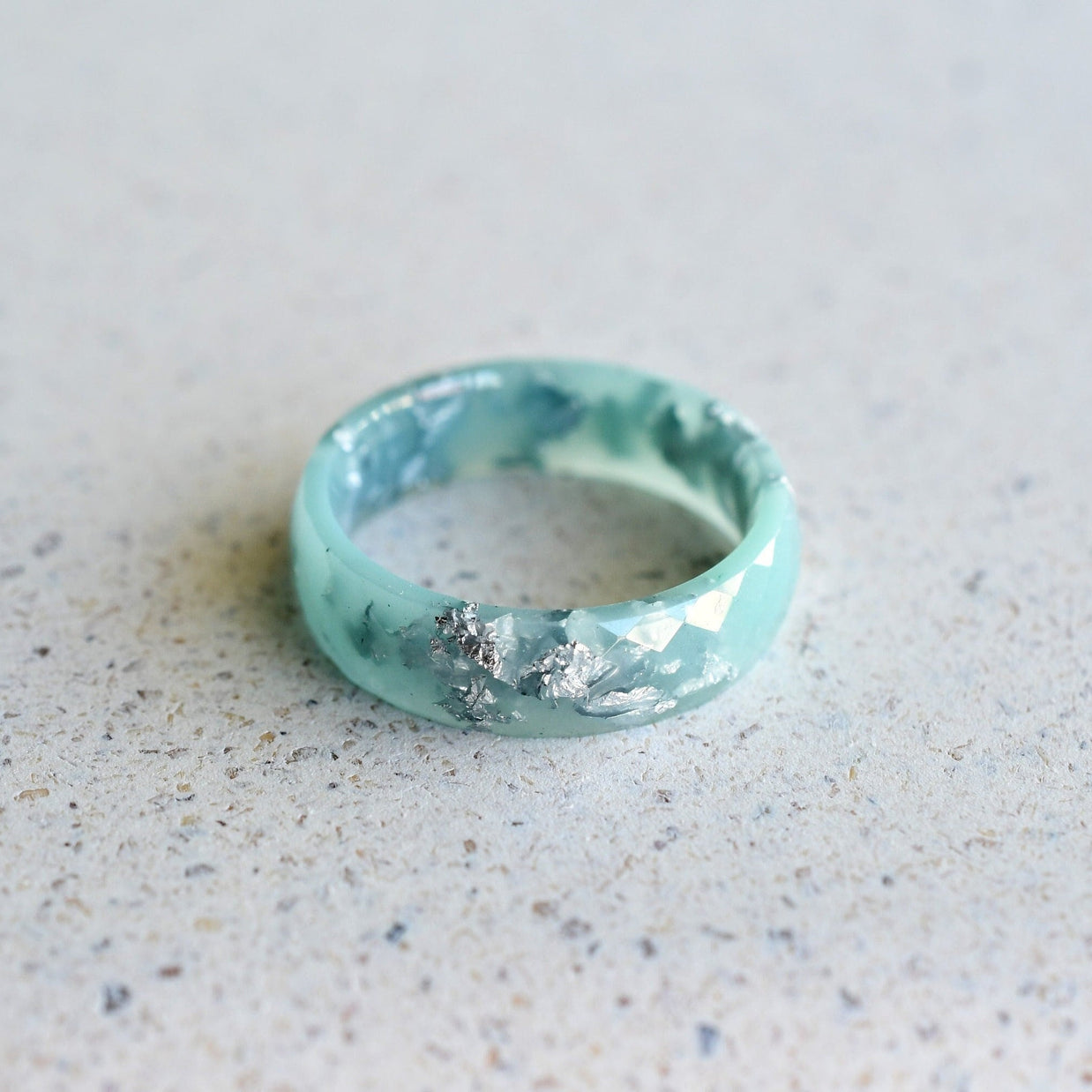 Close-up of silver flakes suspended in mint resin — handmade by Resity