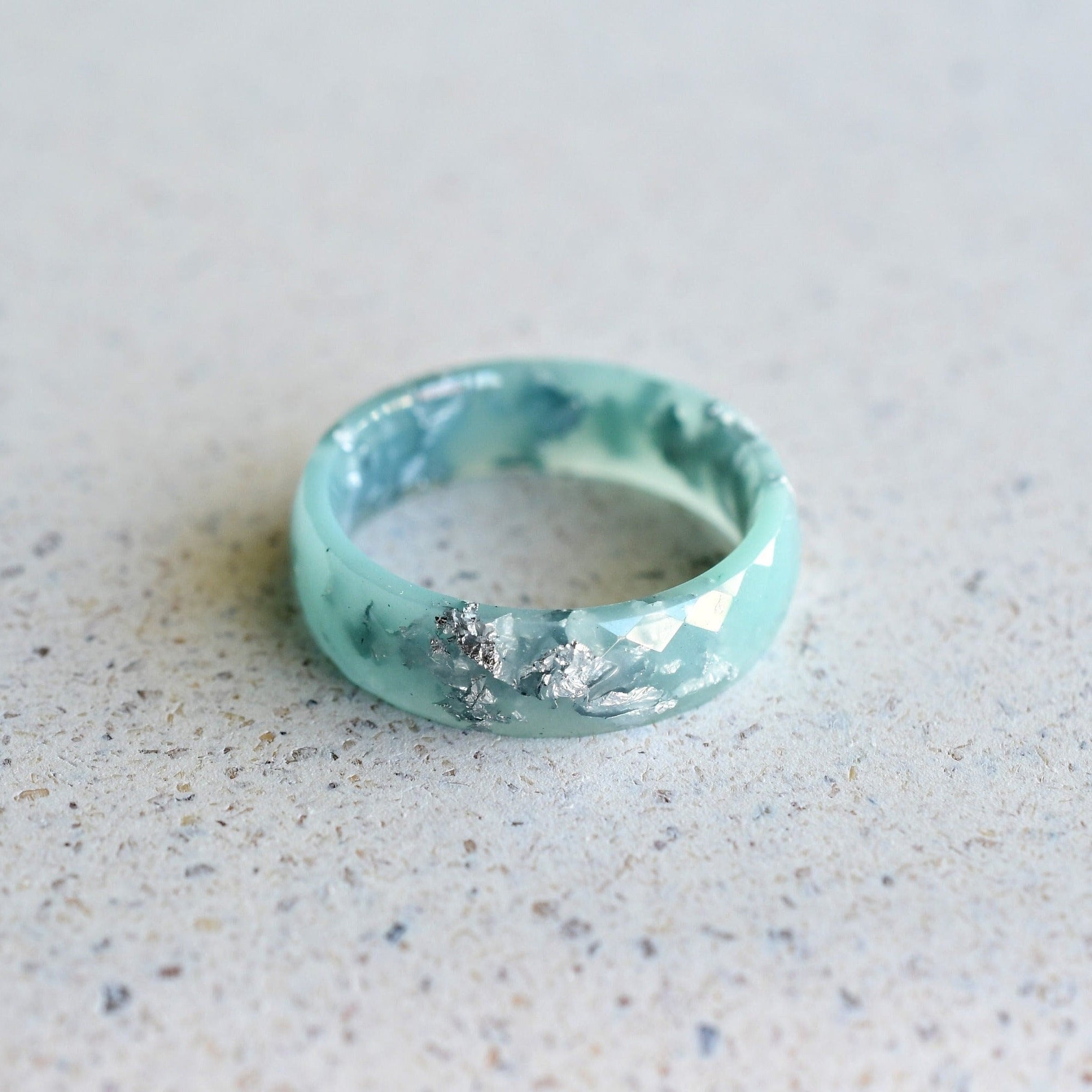 Close-up of silver flakes suspended in mint resin — handmade by Resity