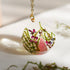 Necklace with a clear pendant featuring pink and green natural elements on a light background