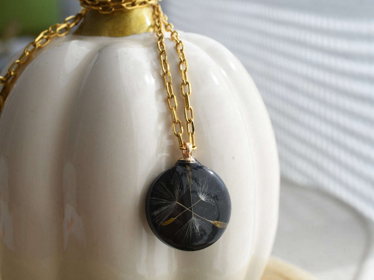 Black resin disc pendant with dandelion seed inclusion, elegant botanical necklace