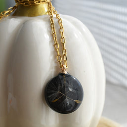 Black resin disc pendant with dandelion seed inclusion, elegant botanical necklace