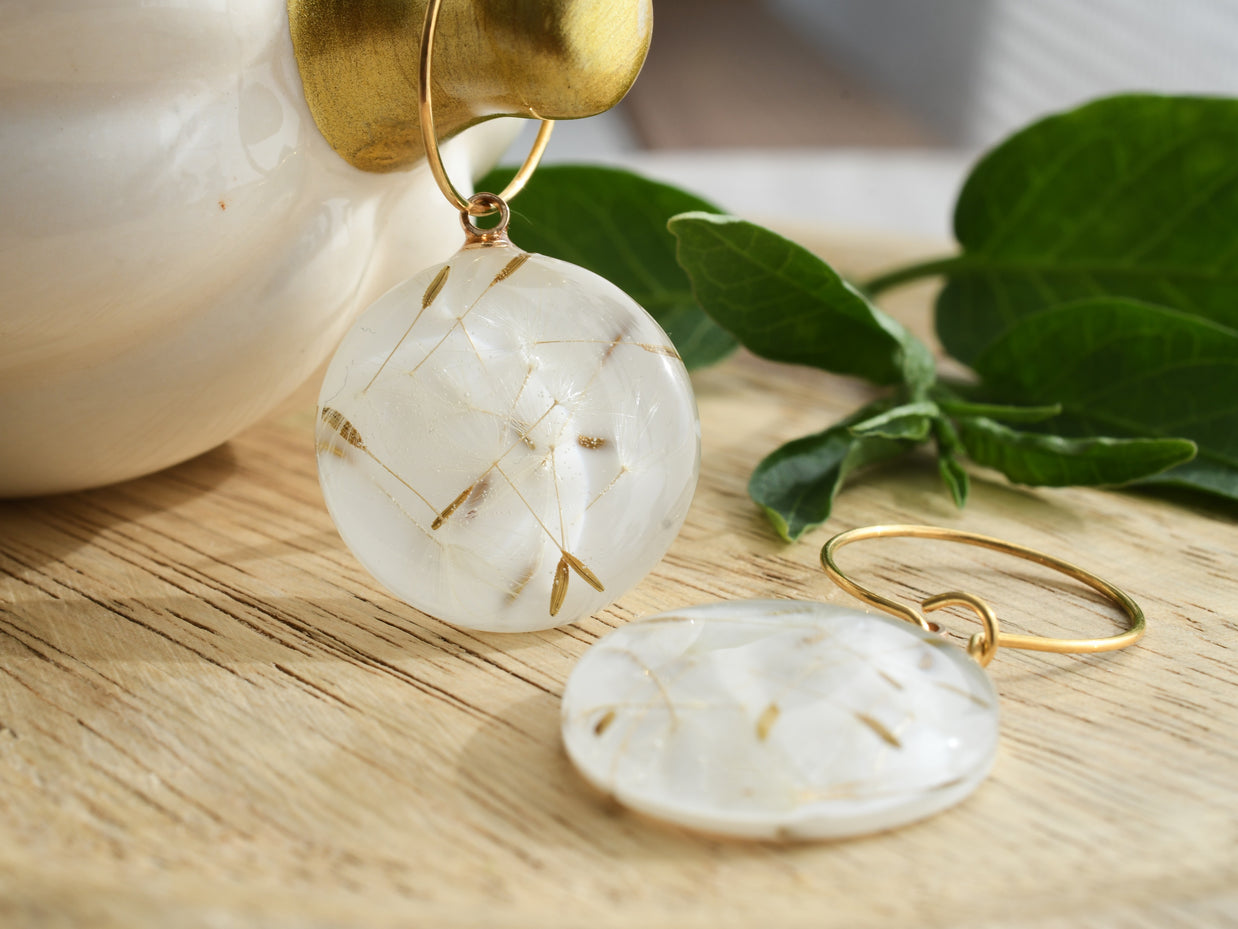Nature-inspired earrings with dandelion seeds preserved in resin, gold hoop detail, lightweight handmade jewelry