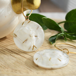 Nature-inspired earrings with dandelion seeds preserved in resin, gold hoop detail, lightweight handmade jewelry