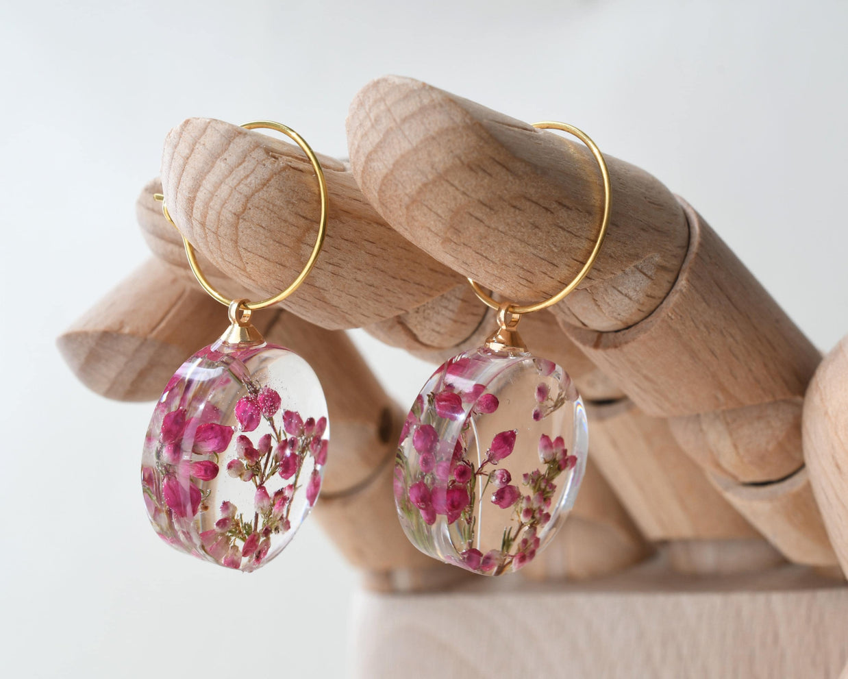 Nature-inspired hoop earrings with preserved heather flowers in resin