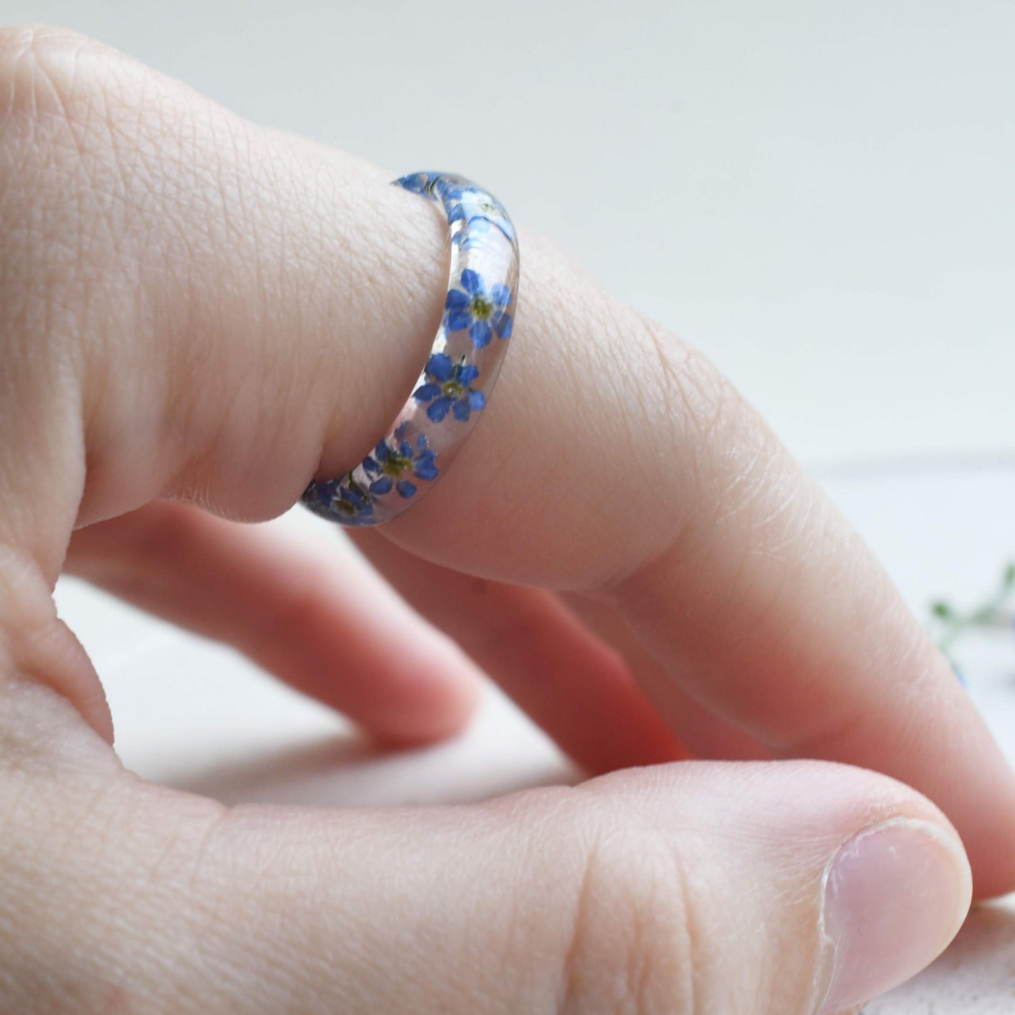 Nature-inspired resin band with blue flowers and metallic silver flakes